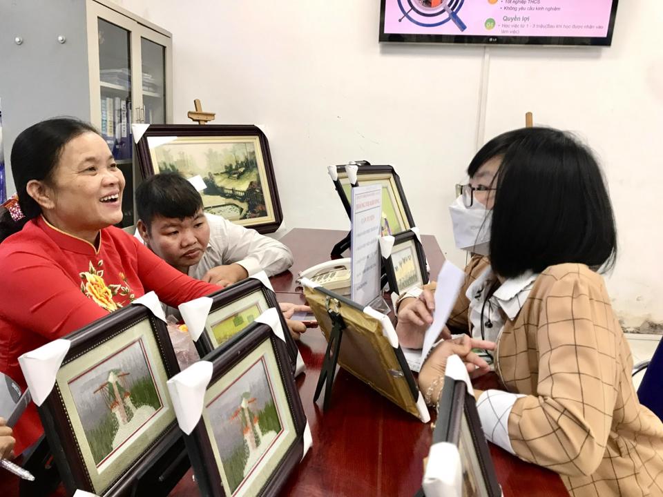 Người khuyết tật đang tìm hiểu thông tin việc làm tại Công ty TNHH Thêu tranh ảnh cao cấp Hoàng Thị Khương. Ảnh: Trần Oanh.