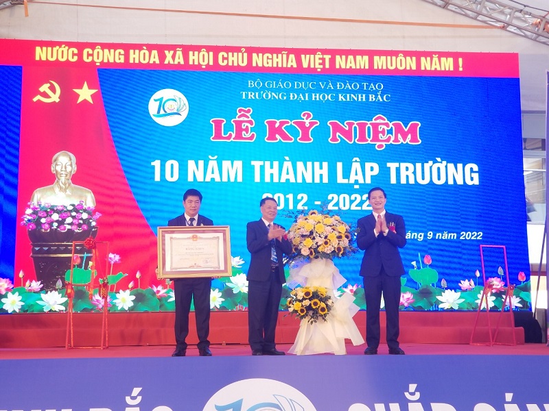 Ông Vương Quốc Tuấn - Phó Chủ tịch Thường trực UBND tỉnh Bắc Ninh trao tặng bằng khen cho ông Đoàn Xuân Tiếp - Chủ tịch HĐQT, và BGH Trường Đại học Kinh Bắc tại Lễ kỷ niệm 10 năm thành lập trường.